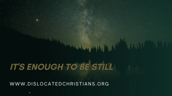 Lake surrounded by trees at night, stars reflecting from it. Milky way